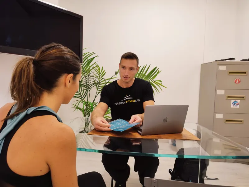 Valutazione iniziale in studio: un professionista ascolta la storia di una cliente seduti alla scrivania.
